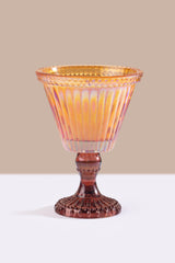 yellow glass goblet with a ribbed design on a beige background