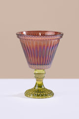 brown glass goblet on a white surface with a beige background